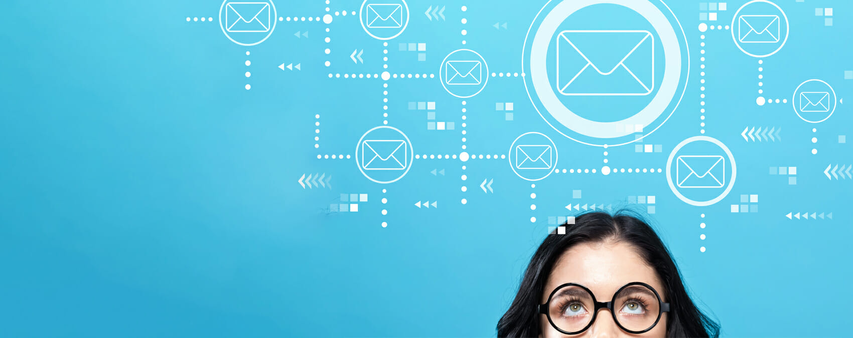 Woman in glasses looks up at email symbols floating above her head